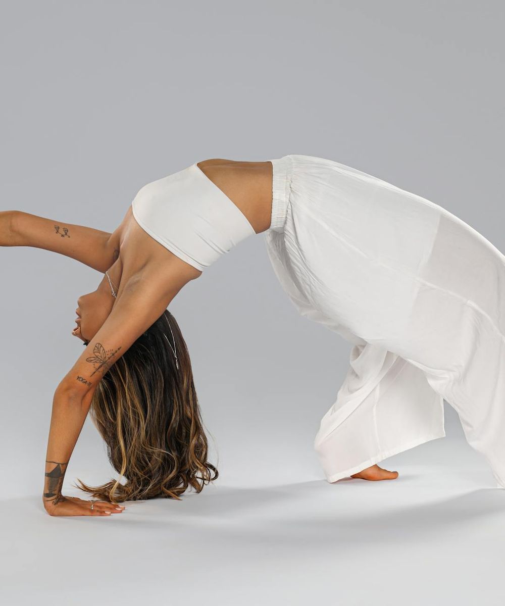 Person performing a balanced yoga pose in dark studio
